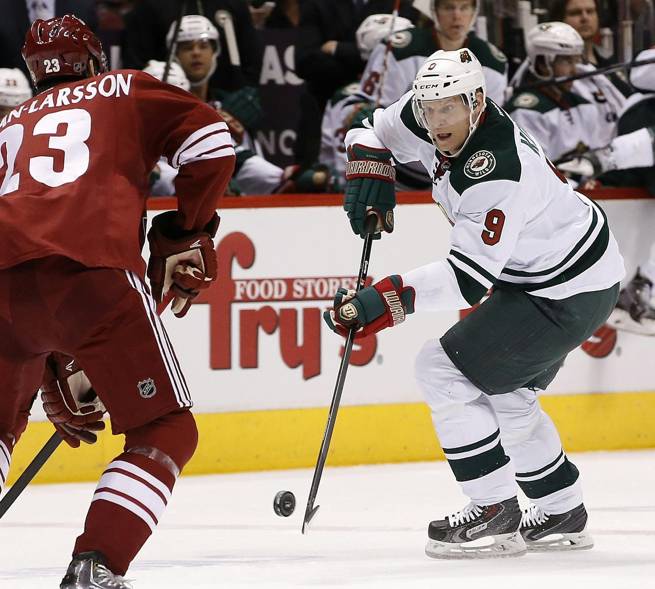 Minnesota Wild's Mikko Koivu (9), of Finland, skates with the puck in front of Phoenix Coyotes' Oliver Ekman-Larsson (23), of Sweden, during the first period of an NHL hockey game, Saturday, March 29, 2014, in Glendale, Ariz. The Wild defeated the Coyotes 3-1. (AP Photo/Ross D. Franklin)