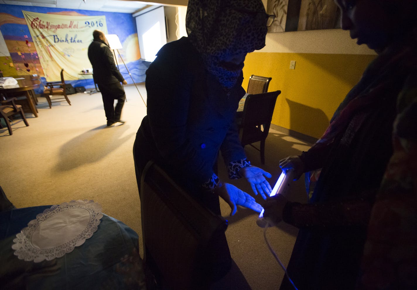 Farhiya Farah tested each class member's freshly washed hands using a blacklight and special lotion that indicates bacteria during a certification class on food safety in Somali on Feb. 24 in Minneapolis.