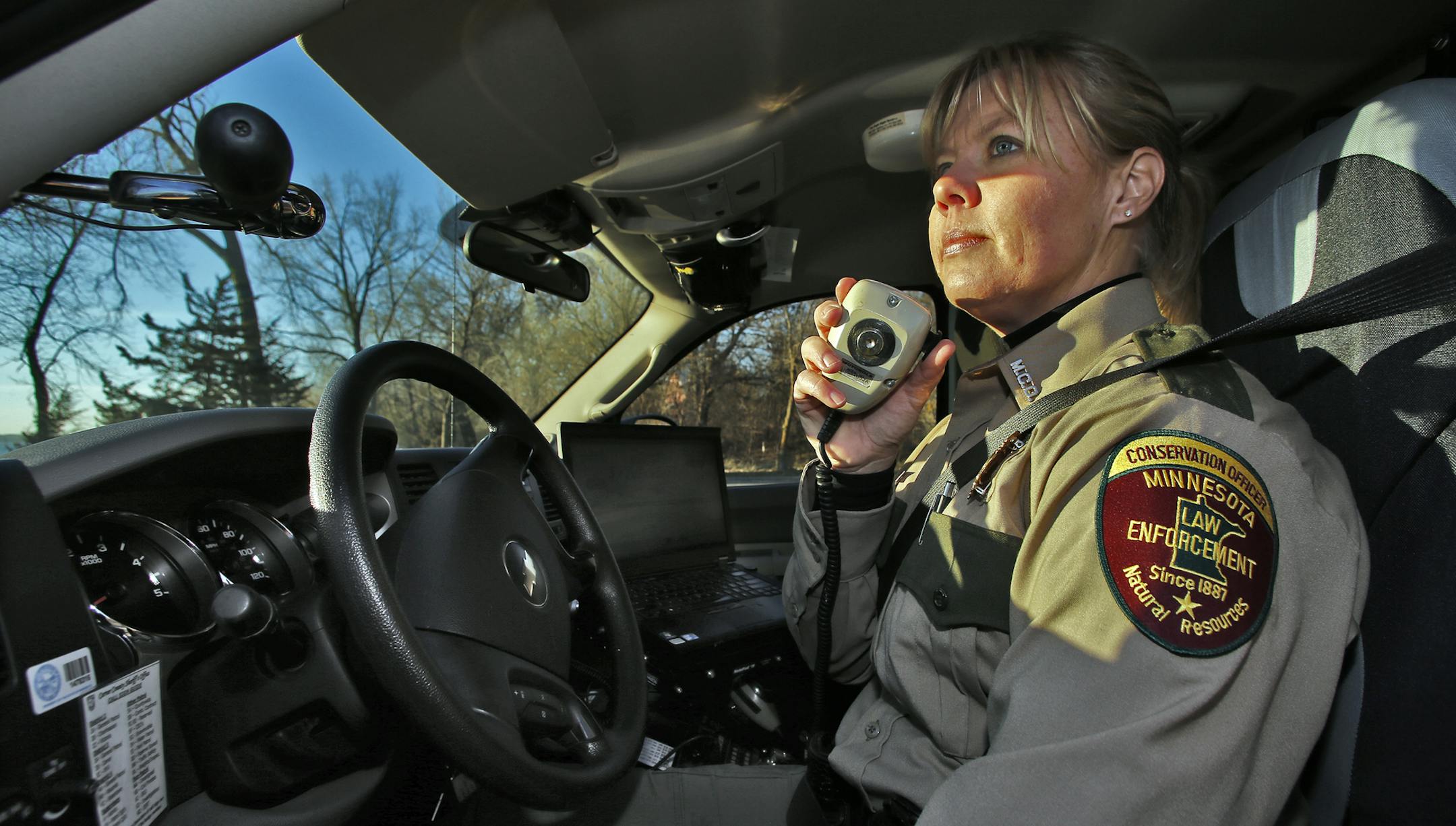 Jackie Glaser is a Minnesota DNR officer working on the west side of the Twin Cities. Glaser juggles her work duties with the responsibilities of being a mother of three young sons. Photos taken on the shore of Lake Waconia. Jackie Glaser on the radio in her DNR vehicle. (MARLIN LEVISON/STARTRIBUNE(mlevison@startribune.com)