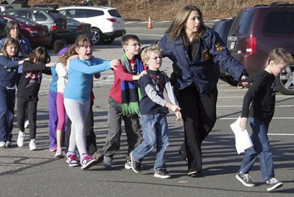 Dec. 12, 2012: Police lead children from the Sandy Hook Elementary School in Newtown, Conn., following a mass shooting at the school.