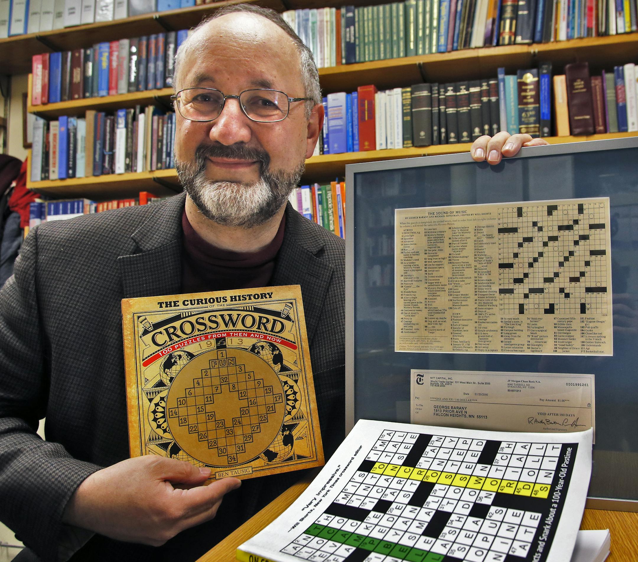 U of M chemistry professor George Barany is a cross word puzzle fan, creating many new puzzles and winning puzzle contests. Here he displays a book showing the first cross word puzzle created in 1913, as well as a display of his first NYT puzzle including the dollar he kept from the prize money. (MARLIN LEVISON/STARTRIBUNE(mlevison@startribune.com)