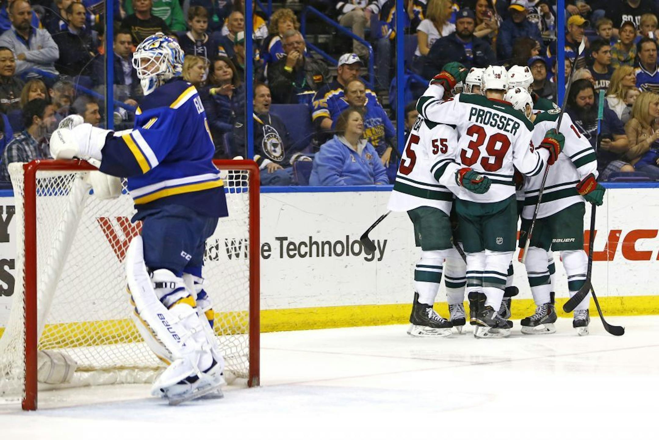 St. Louis Blues goalie Brian Elliott reacts as members of the Minnesota Wild celebrate a goal scored by Thomas Vanek during the second period of an NHL hockey game Saturday, March 14, 2015, in St. Louis.