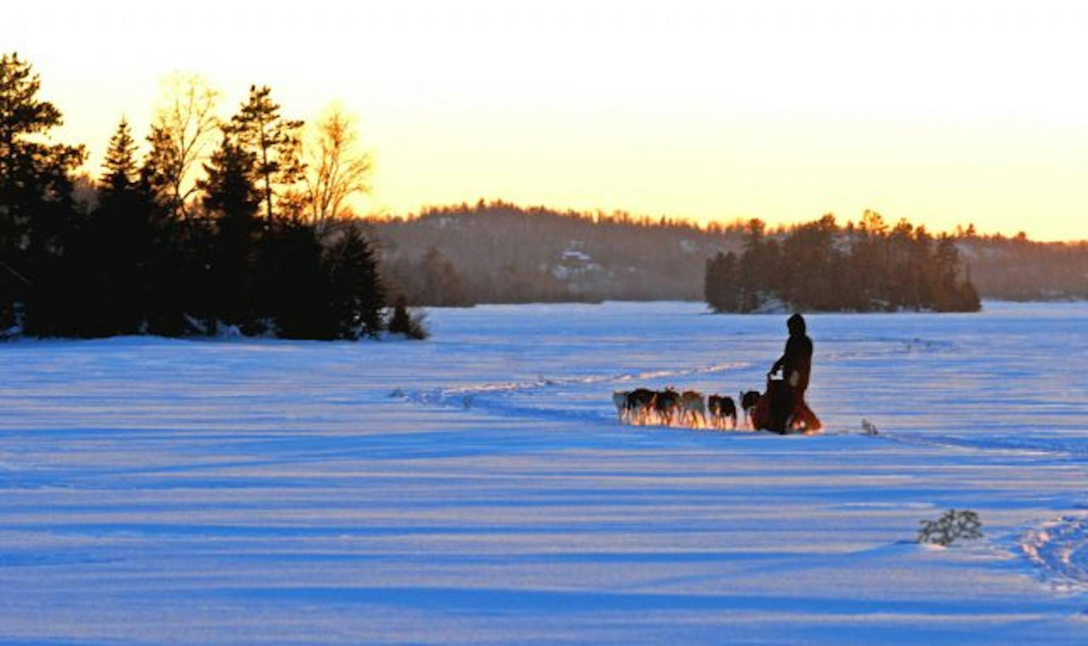 As the sun setover the frozen boundary waters, Stu McEntyre of Ely guided his dog team across Moose Lake.