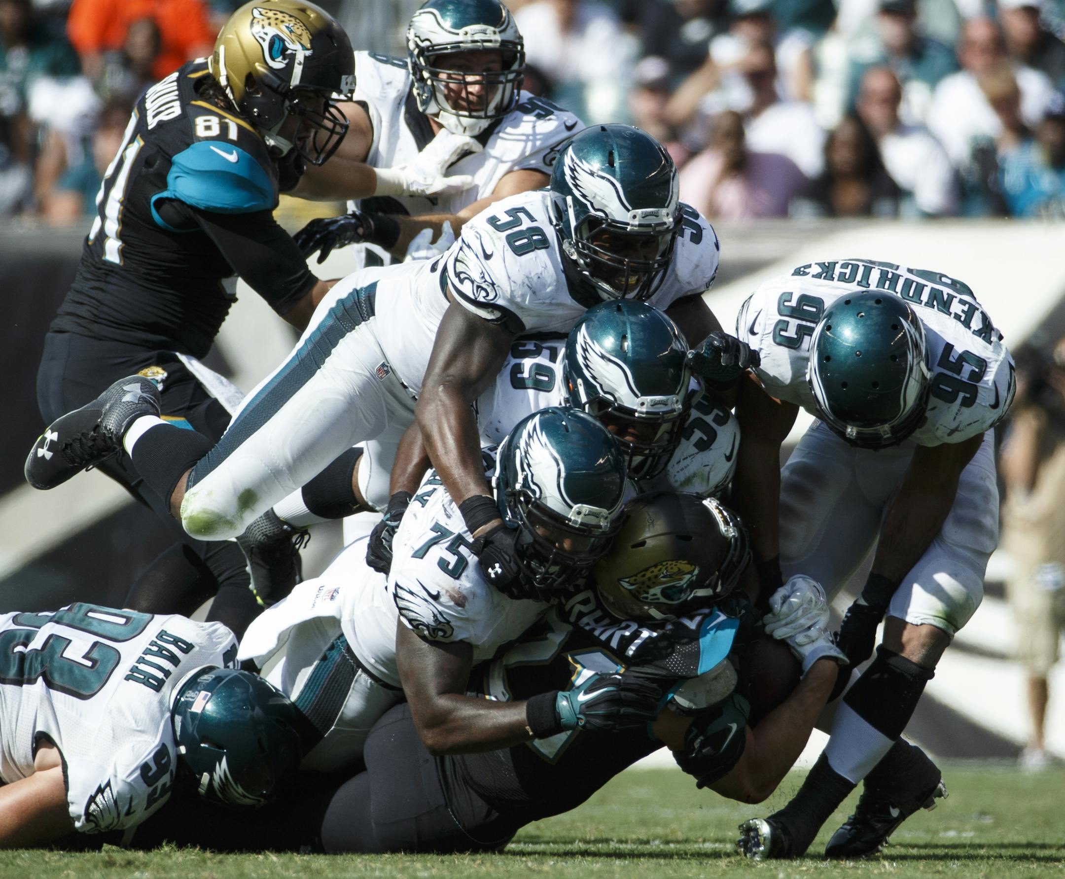 Jacksonville Jaguars running back Toby Gerhart, bottom, gets gang tackled by the Philadelphia Eagles defense, (left to right), Brandon Bair, Vinny Curry, Trent Cole, DeMeco Ryans and Mychal Kendricks during the second half of an NFL football game, Sunday, Sept. 7, 2014, in Philadelphia. The Eagles won 34-17. (AP Photo/Chris Szagola) ORG XMIT: OTKCS196