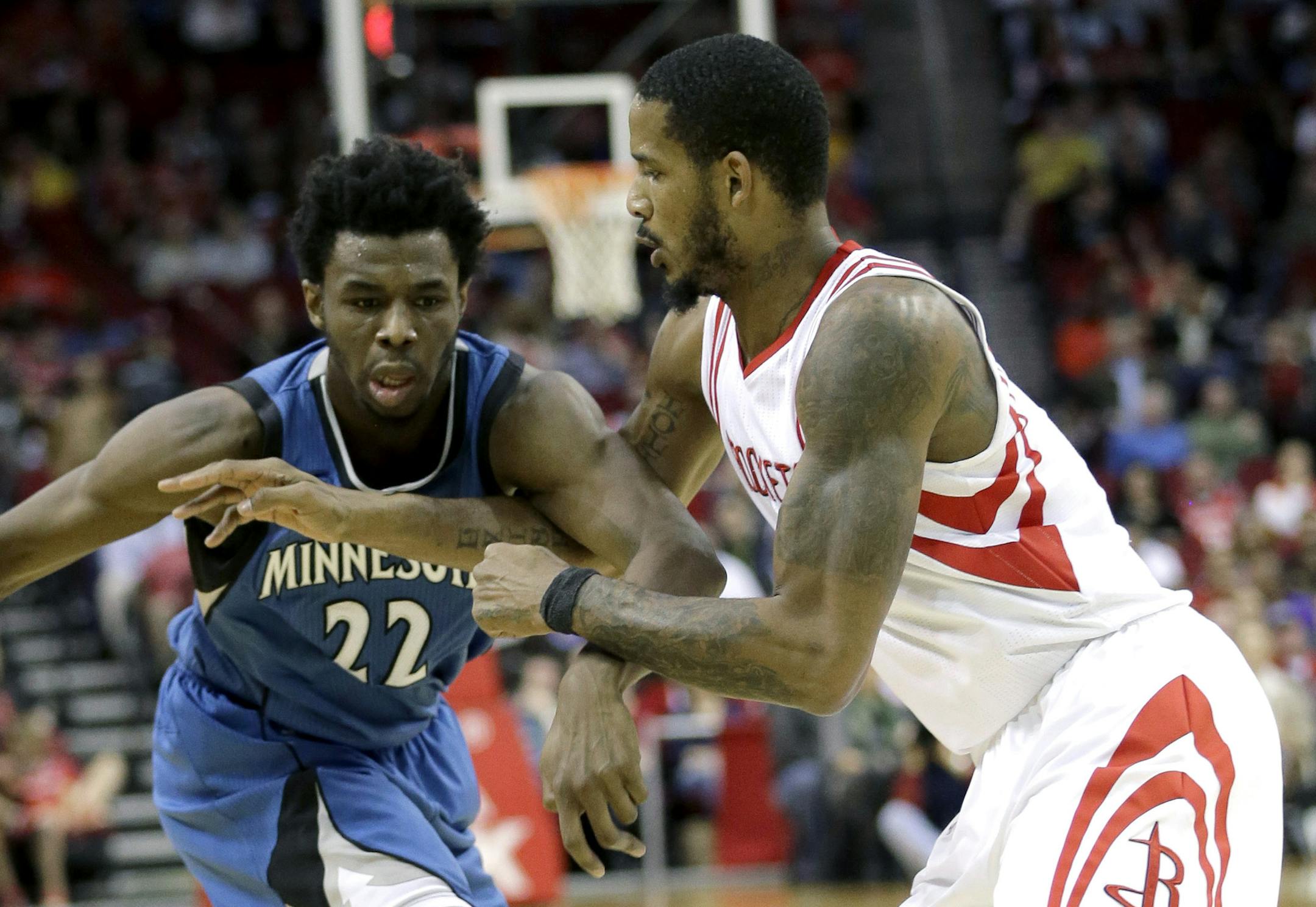 Minnesota Timberwolves' Andrew Wiggins (22) keeps the ball from Houston Rockets' Trevor Ariza during the first quarter of an NBA basketball game Wednesday, Jan. 13, 2016, in Houston. (AP Photo/David J. Phillip)