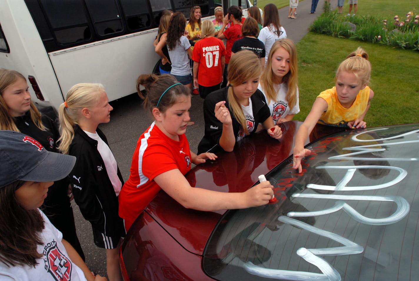 Members of the St. Croix Swarm decorated the rear window of one of the carpool vehicles before heading up to Duluth for a tournament. Behind them, by the bus, are the St. Croix Arsenal team members who were riding up to the tourney on the bus. (The Swarm is a 13 years old and under team and the Arsenal is a 19 years old and under team.) Holding the marker is Jaci Beck and (left to right from Beck is Chelsey Bechel, Anna Pedersen and Sally Bisch--all are 13 years old.) The Swarm coach, Bill Lutin