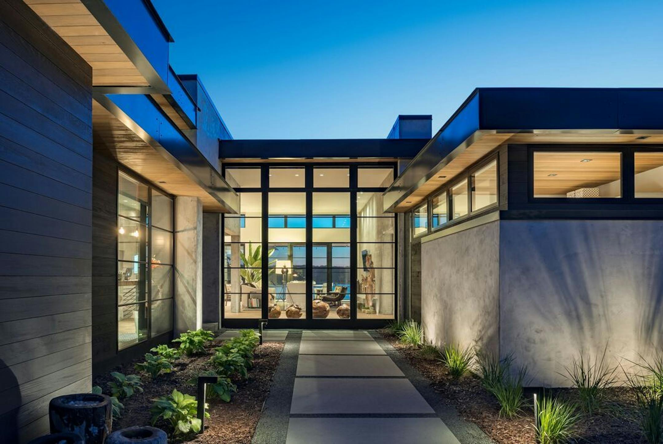 The connection to the lake begins as you approach the house and see the lake through the glass entry and beyond the living room.
