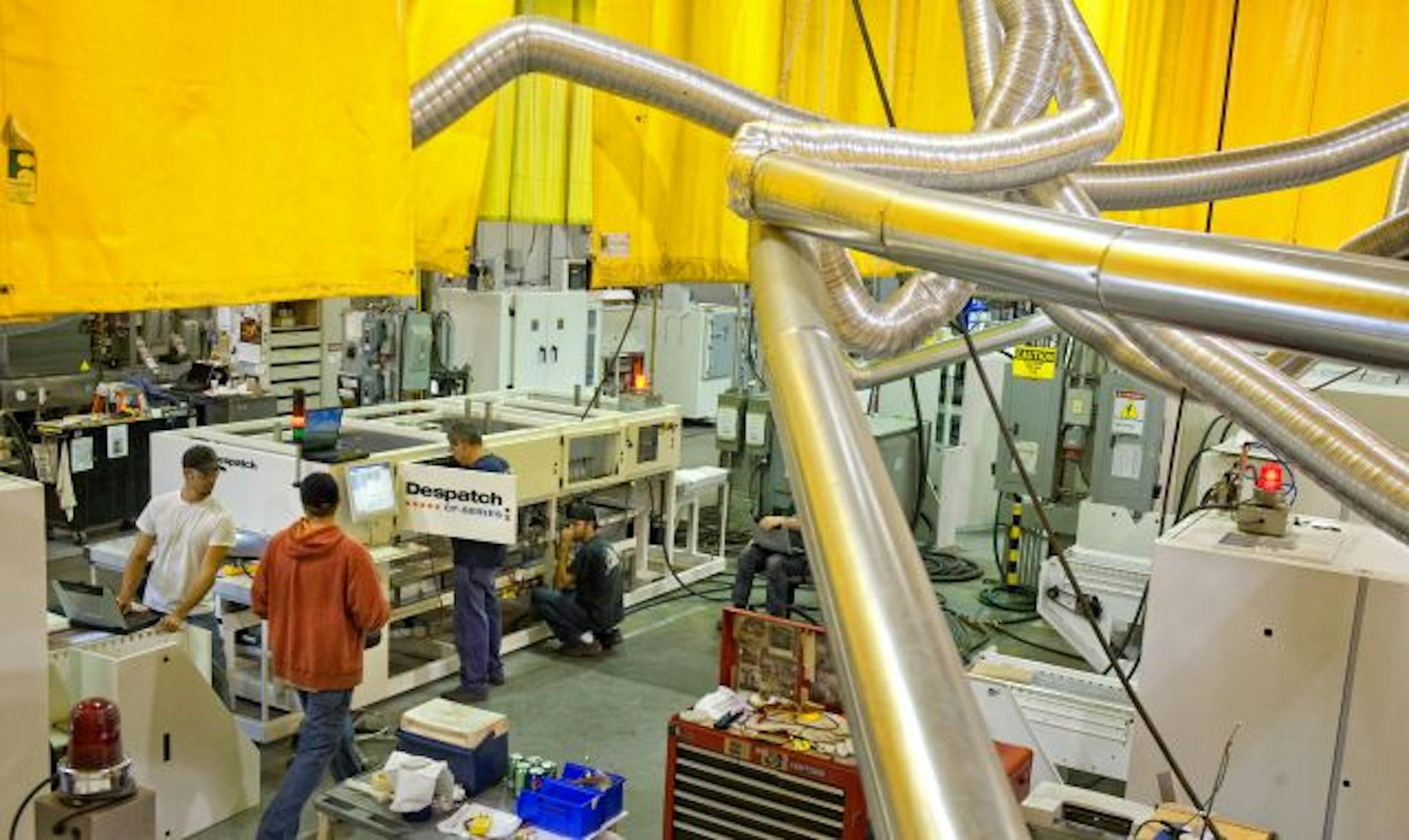 Flexible exhaust pipes vent the heat generated when workers at Despatch Industries test their firing furnaces to 1,800 degrees.