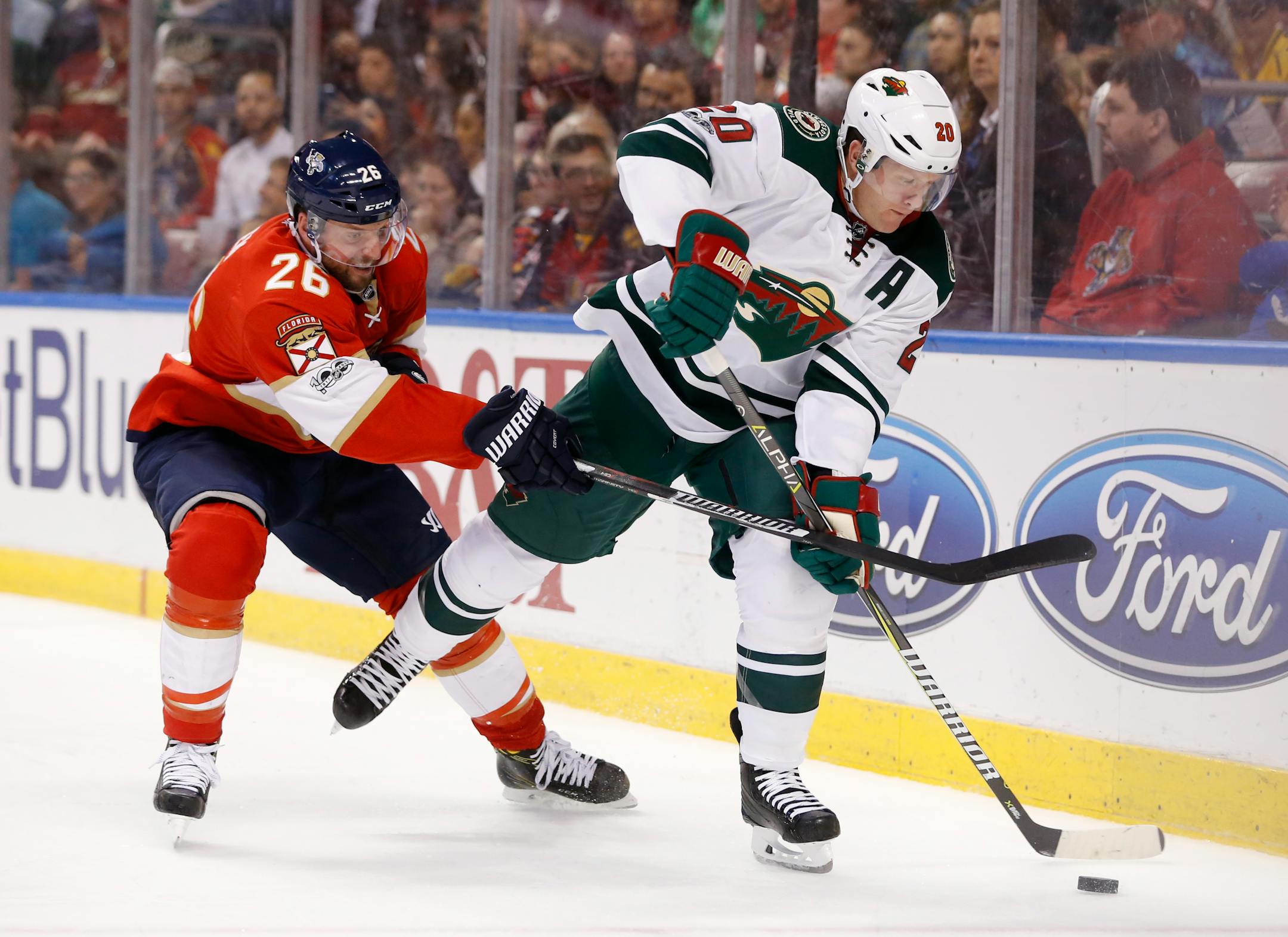 Florida Panthers left wing Thomas Vanek (26) and Minnesota Wild defenseman Ryan Suter (20) battle for the puck during the second period of an NHL hockey game, Friday, March 10, 2017, in Sunrise, Fla.