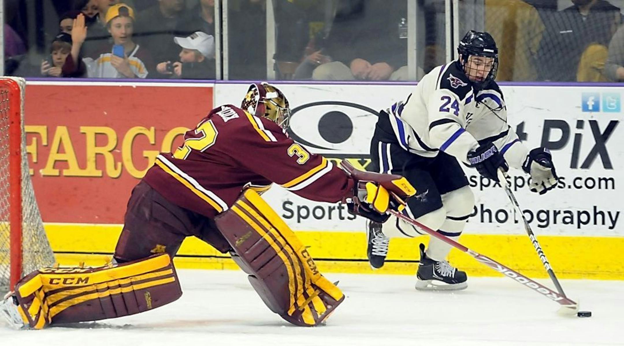 Minnesota goalie Adam Wilcox pokes the puck away from Minnesota State-Mankato's Brett Knowles during the first period of a college hockey game on Saturday, Jan. 26, 2013, in Mankato, Minn.