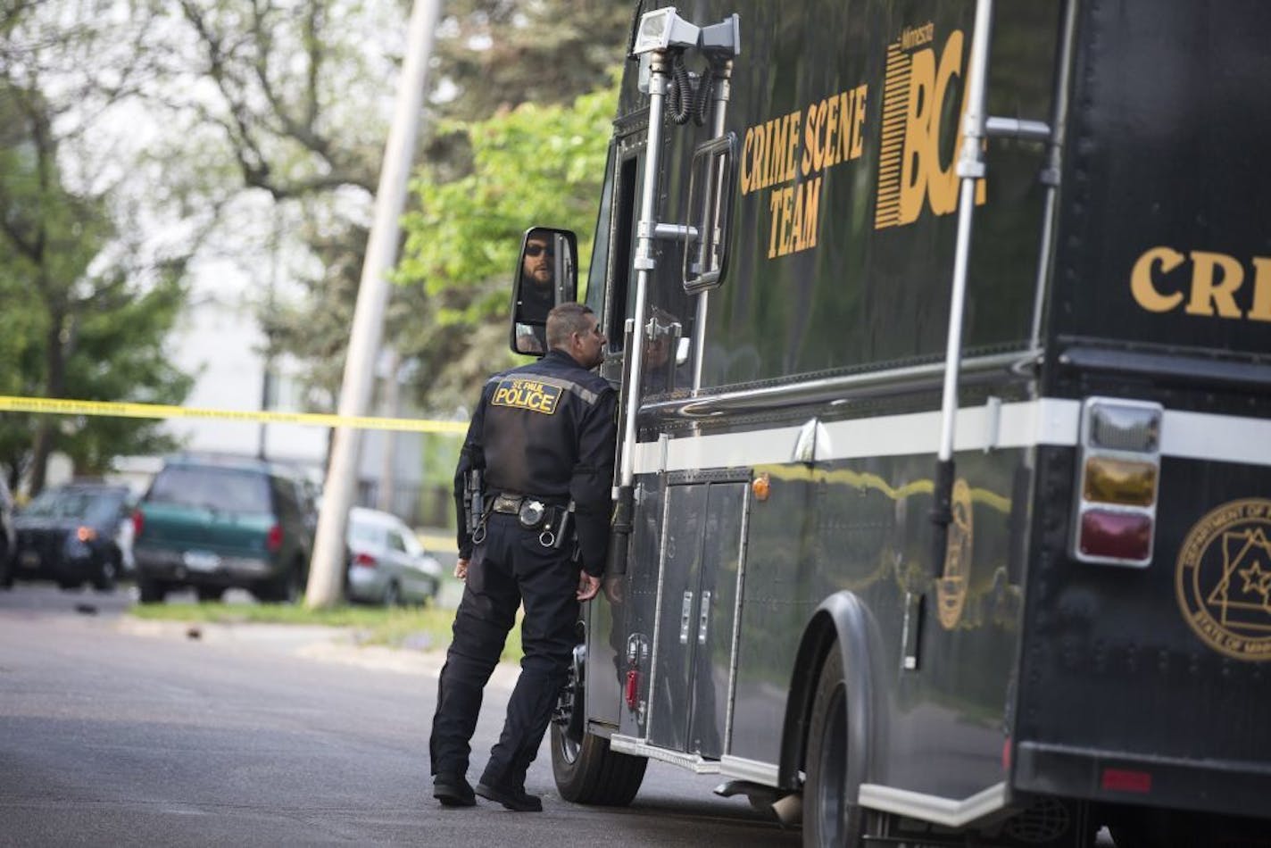 Police investigate a scene where shots were fired in St. Paul with a Minnesota BCA Crime Scene Team truck.