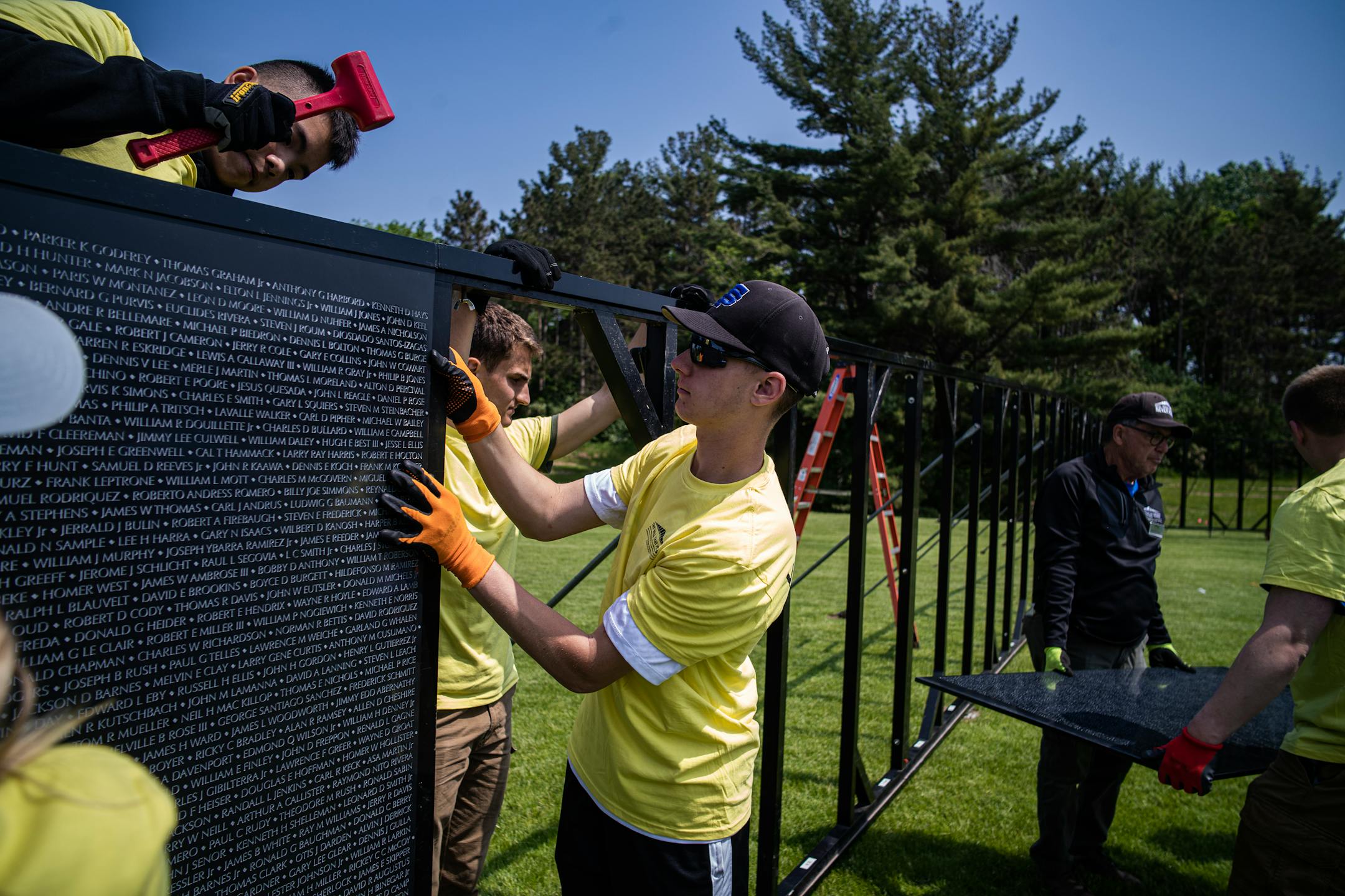 St. Thomas Academy cadets and volunteers help assemble a 3/4 scale of the Wall That Heals that contains 58,281 names of Vietnam Veterans who died.