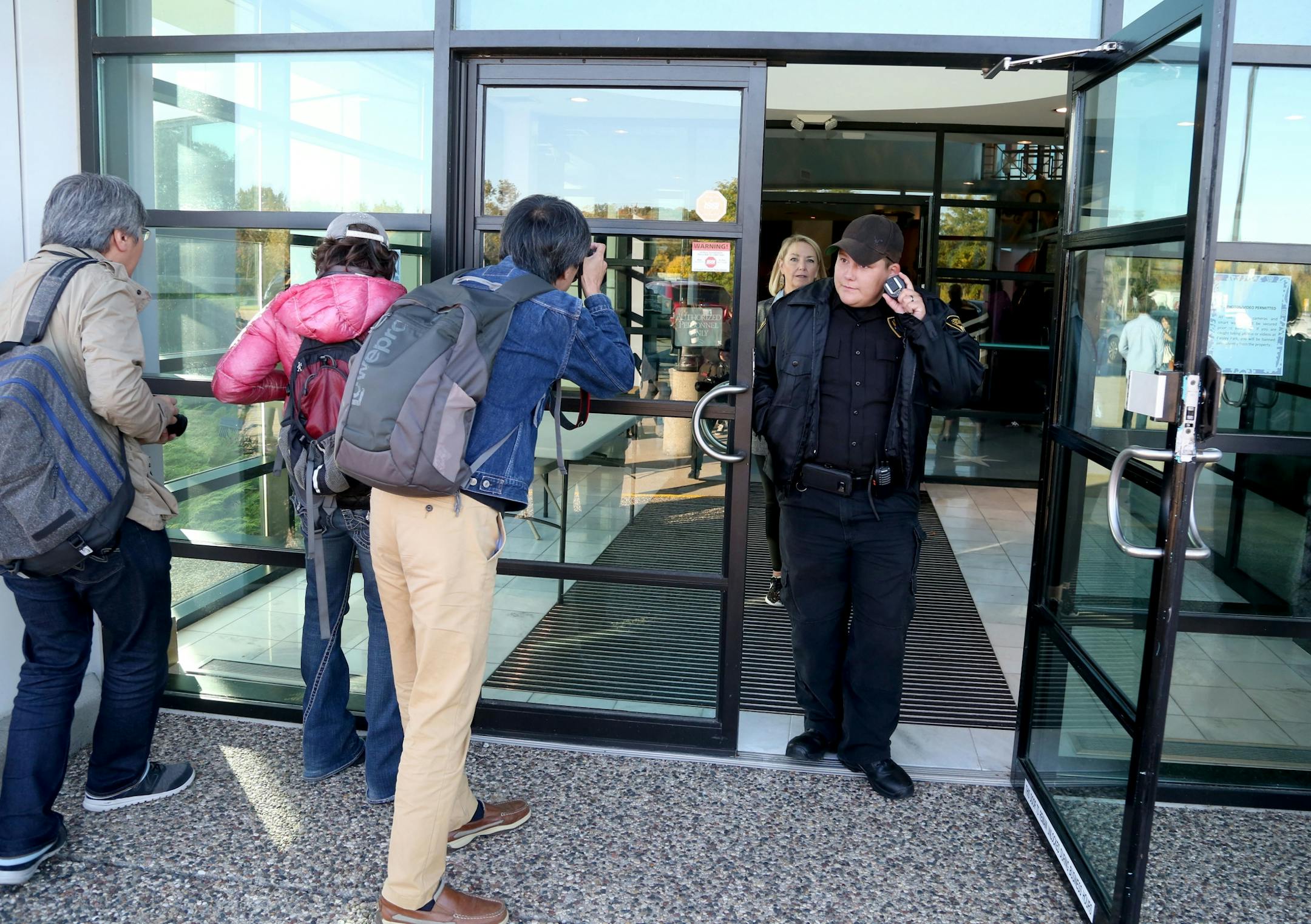 A security guard, who declined to give a name, stands guard at the front door as media members try to peak inside for the first Paisley Park Tour Thursday, Oct. 6, 2016, in Chanhassen, MN.