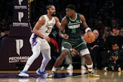 Lakers guard Spencer Dinwiddie (26) defends against Timberwolves guard Anthony Edwards (5) during the second half Sunday in Los Angeles.
