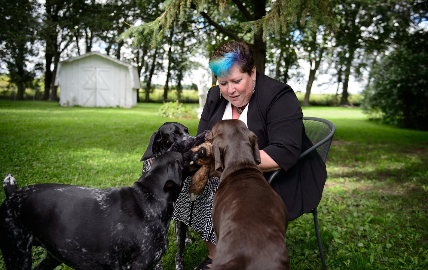 Sue Olson at her Austin, MN home with some of her four German Shorthair Pointers. She is hoping to adopt a 13-year-old girl. ] GLEN STUBBE * gstubbe@startribune.com Friday September 11, 2015 Two children forced to watch their father murder their mother five years ago are still in foster care, despite state laws that require child protection to find the kids an immediate home. One of the kids, 13-year-old Joan, has Sue Olson waiting to adopt her, but the county won't let that go through, citing a