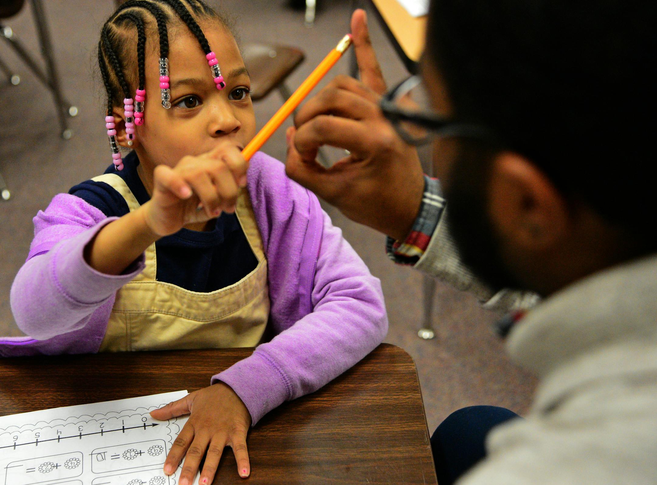 Jayden Myles is a navigator which is like a mentor who works with students in the NAZ program. He works with these young scholars one on one focusing on strengths and weaknesses of students while building esteem and improving academic outcomes. He was working on math skills with Ahzaneia Cook during an after school program ] Nellie Stone Johnson Community School is in the Northside Achievement Zone. Richard.Sennott@startribune.com Richard Sennott/Star Tribune Minneapolis , Minn.Wednesday 3/26/20