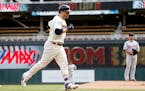 Minnesota Twins' Brian Dozier jogs home after hitting a solo home run off Detroit Tigers pitcher Anibal Sanchez, right, during the first inning in the