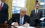 FILE - In this Monday, Jan. 23, 2017, file photo, President Donald Trump signs an executive order to withdraw the U.S. from the 12-nation Trans-Pacifi