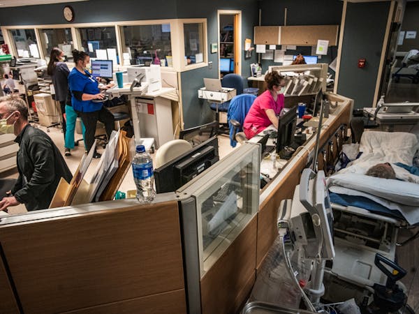 Because of the shortage of beds, patients are placed and seen in the hallways of the emergency department in Maplewood, Minn., on Thursday, Nov. 3, 20