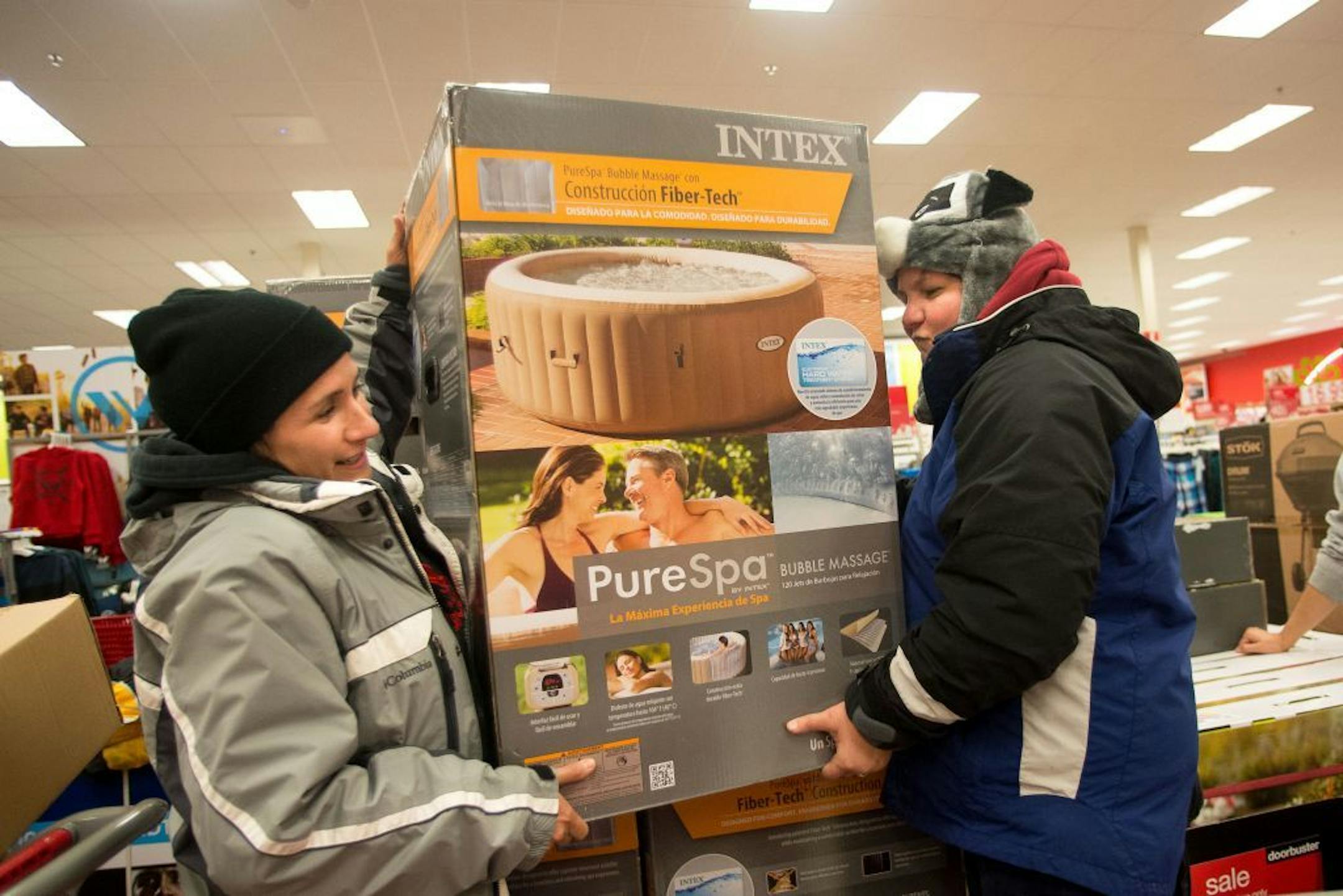 Karen Villanueva, left, and Rita Pollarolo lift an inflatable hot tub into their cart while shopping at Super Target on Thanksgiving night.