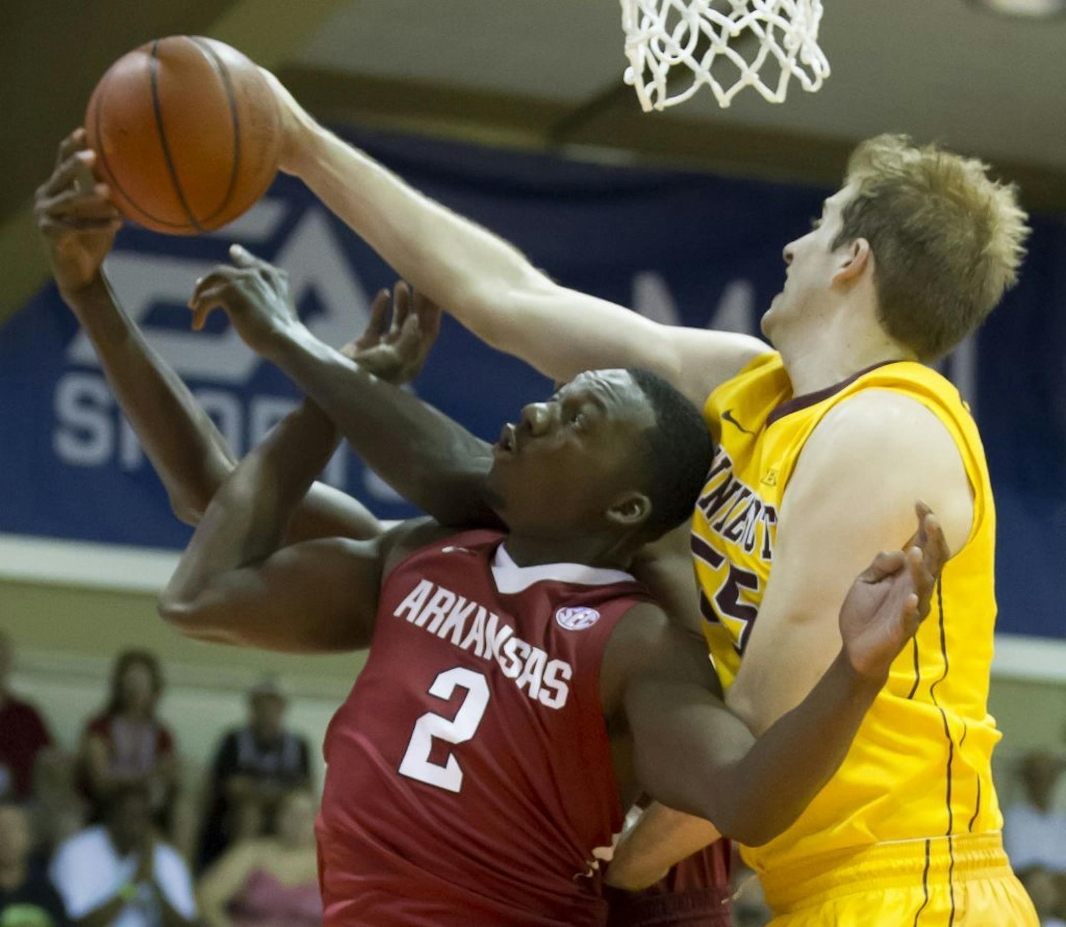 Arkansas forward Alandise Harris (2) and his teammate forward Bobby Portis, back, along with Minnesota center Elliott Eliason, right, try to grab a rebound in the first half of an NCAA college basketball game at the Maui Invitational on Tuesday, Nov. 26, 2013, in Lahaina, Hawaii.