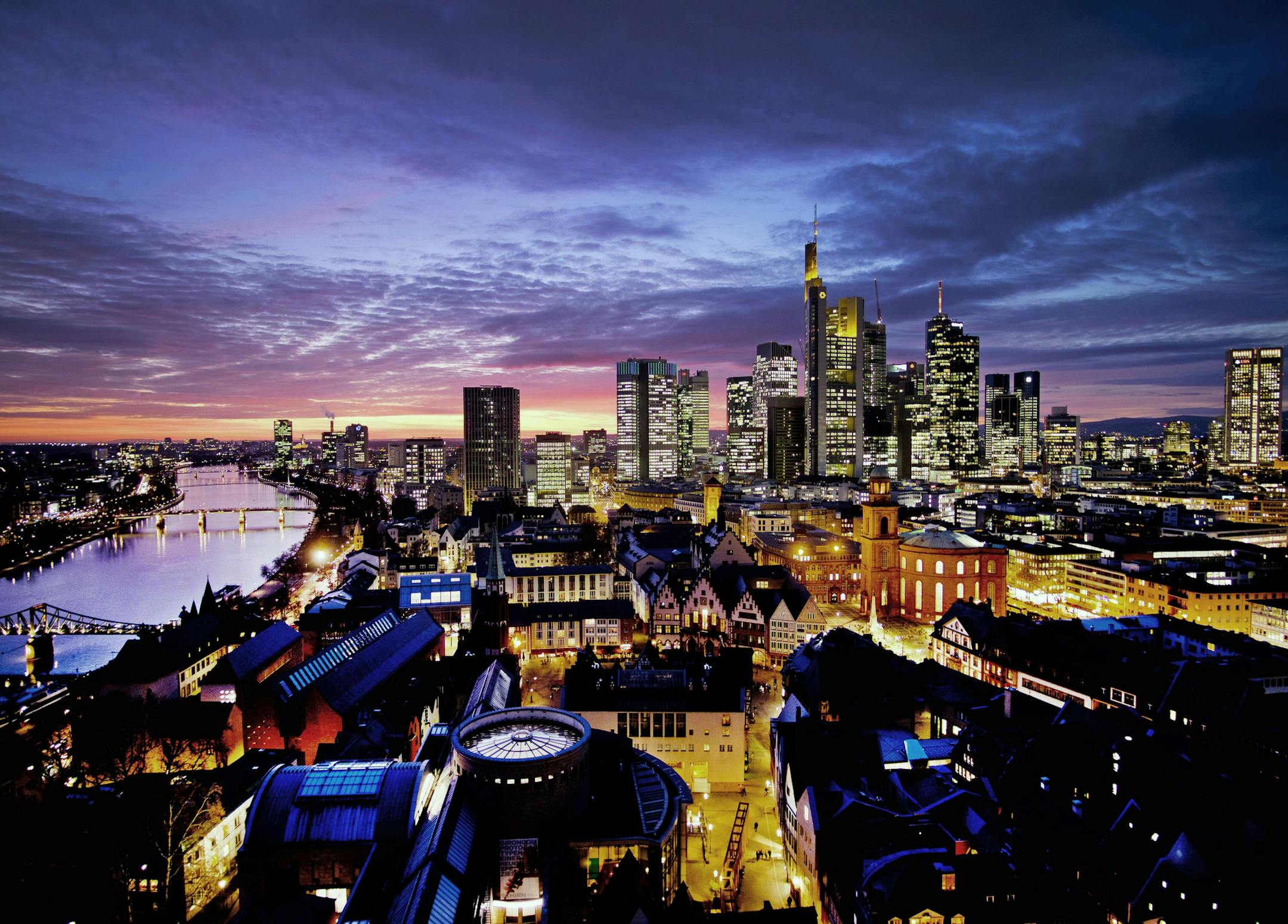 FILE - In this Tuesday, Feb. 12, 2019 file photo, the sun sets over the city of Frankfurt with the buildings of the banking district. Germany, Europe's industrial powerhouse and biggest economy, with companies like Volkswagen, Siemens and BASF, may be entering a recession, according to a gloomy report from the country's central bank Monday, August 19, 2019. (AP Photo/Michael Probst, File)