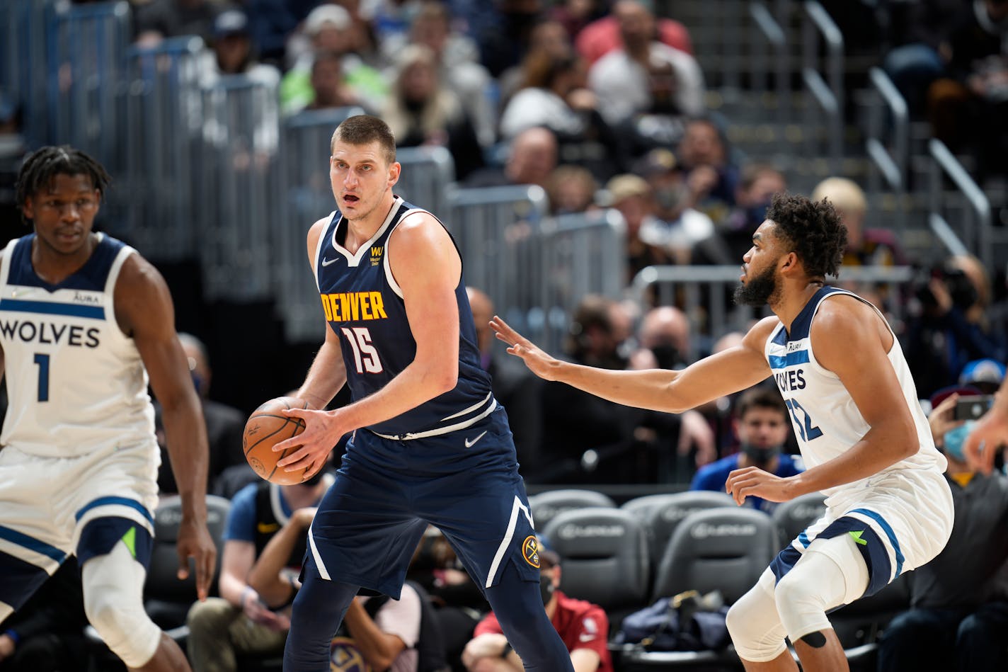 Denver Nuggets center Nikola Jokic (15) and Minnesota Timberwolves center Karl-Anthony Towns (32) in the first half of an NBA basketball game Wednesday, Dec. 15, 2021, in Denver. (AP Photo/David Zalubowski)