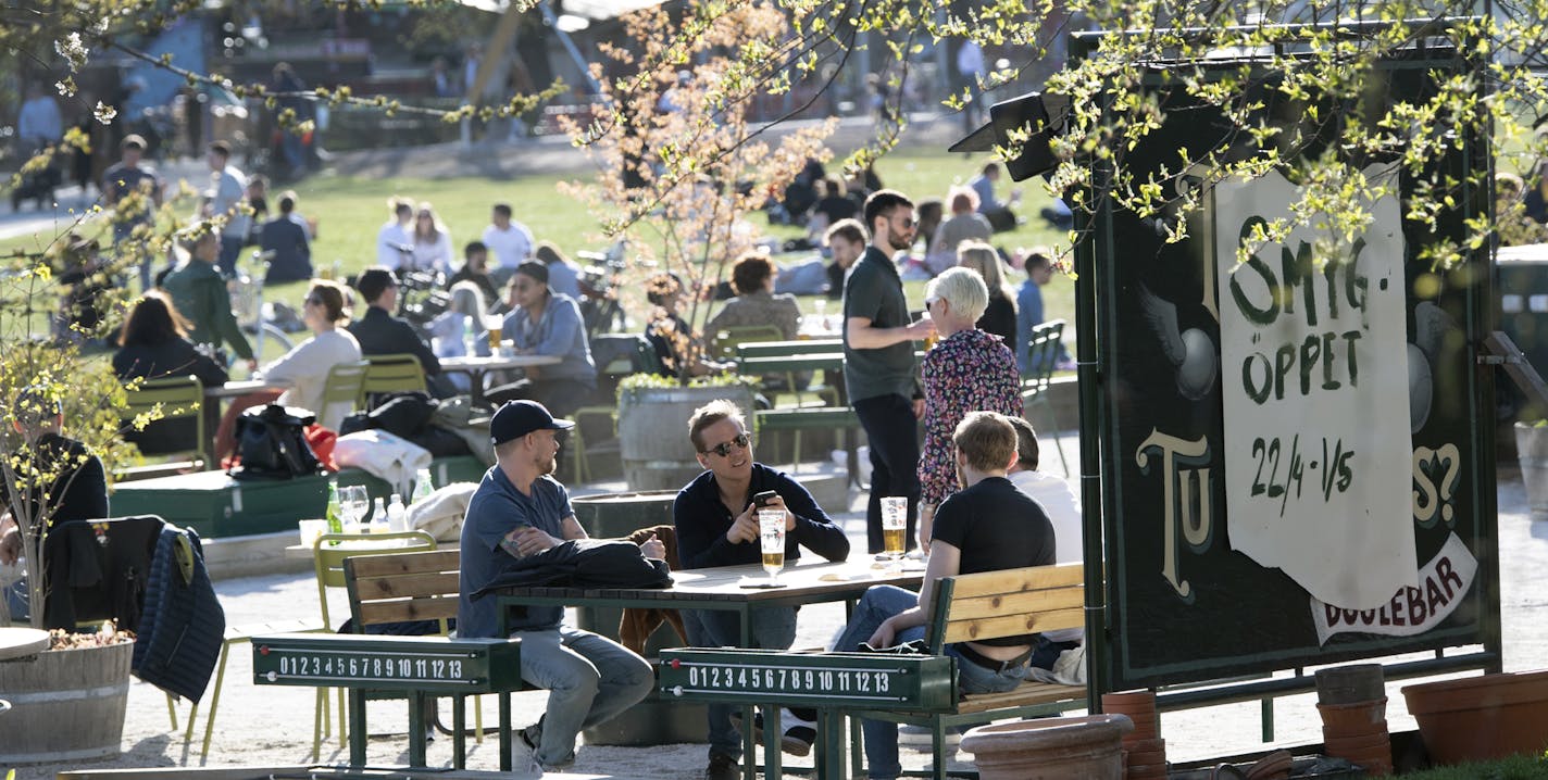 People gather for a drink at an outdoor bar in Stockholm, Sweden, Wednesday April 22, 2020 despite the coronavirus COVID-19 outbreak. (Anders Wiklund/TT via AP)