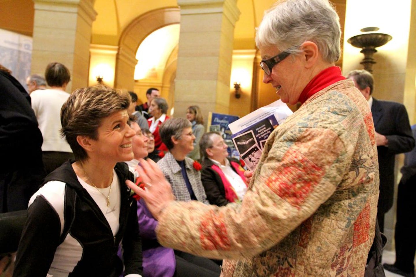 Minnesota Olympic marathon runner Janis Klecker (cq/source) speaks with fellow marathon runner and DFL House Representative Phyllis Kahn at the National Girls and Women in Sports Day at the Minnesota State Capitol rotunda. Kahn, Klecker and Klecker's mother had seen each other in local marathons for many years.