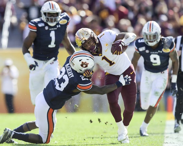 Auburn Tigers defensive back Roger McCreary (23) tackled Minnesota Gophers running back Rodney Smith (1) out of bounds in the second quarter as Smith 