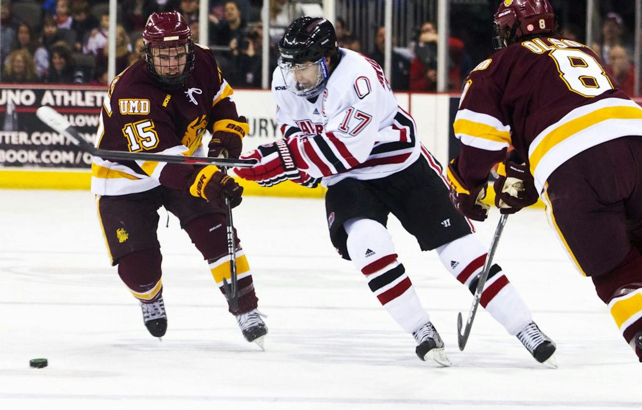 Nebraska-Omaha's Terry Broadhurst (17) tries to skate between Minnesota-Duluth's Jake Hendrickson (15) and Drew Olson (8) during an NCAA hocky game Saturday Jan. 14, 2011 in Omaha Neb. (AP Photo, The Omaha World-Herald, Chris Machian) MAGS OUT TV OUT.