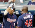 Minnesota Twins' Kurt Suzuki, left, congratulates teammate Torii Hunter after Hunter scored on an RBI-single by Joe Mauer in the first inning of a bas