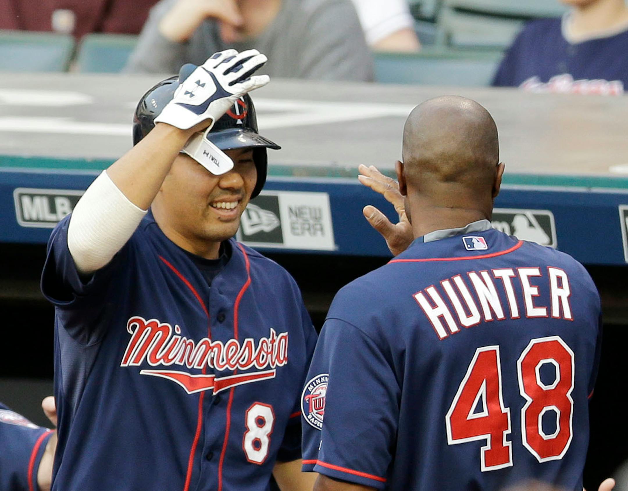 Minnesota Twins' Kurt Suzuki, left, congratulates teammate Torii Hunter after Hunter scored on an RBI-single by Joe Mauer in the first inning of a baseball game against the Cleveland Indians, Friday, May 8, 2015, in Cleveland. (AP Photo/Tony Dejak)