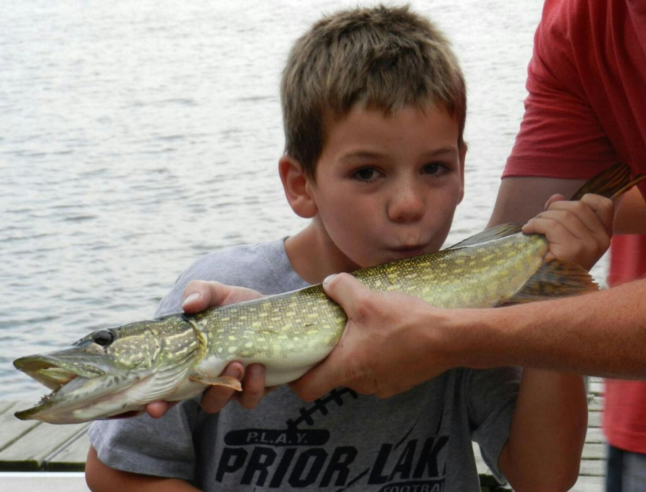 KISS GOODBYE: Ryan O'Connor, 10, of Savage was fishing in 3 feet of water off a dock in Crow Wing Lake looking for sunfish when this 24-inch northern hit. His brother and cousin almost convinced him that he was hooked on a log or the dock. After landing it and snapping some photos, Ryan released it.