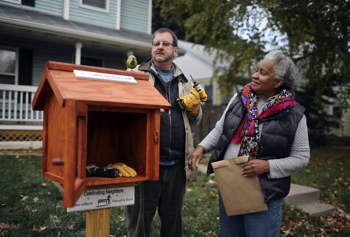 Todd Bol helped Eddye Watkins erect a Little Free Library on her yard in Minneapolis in October 2013.