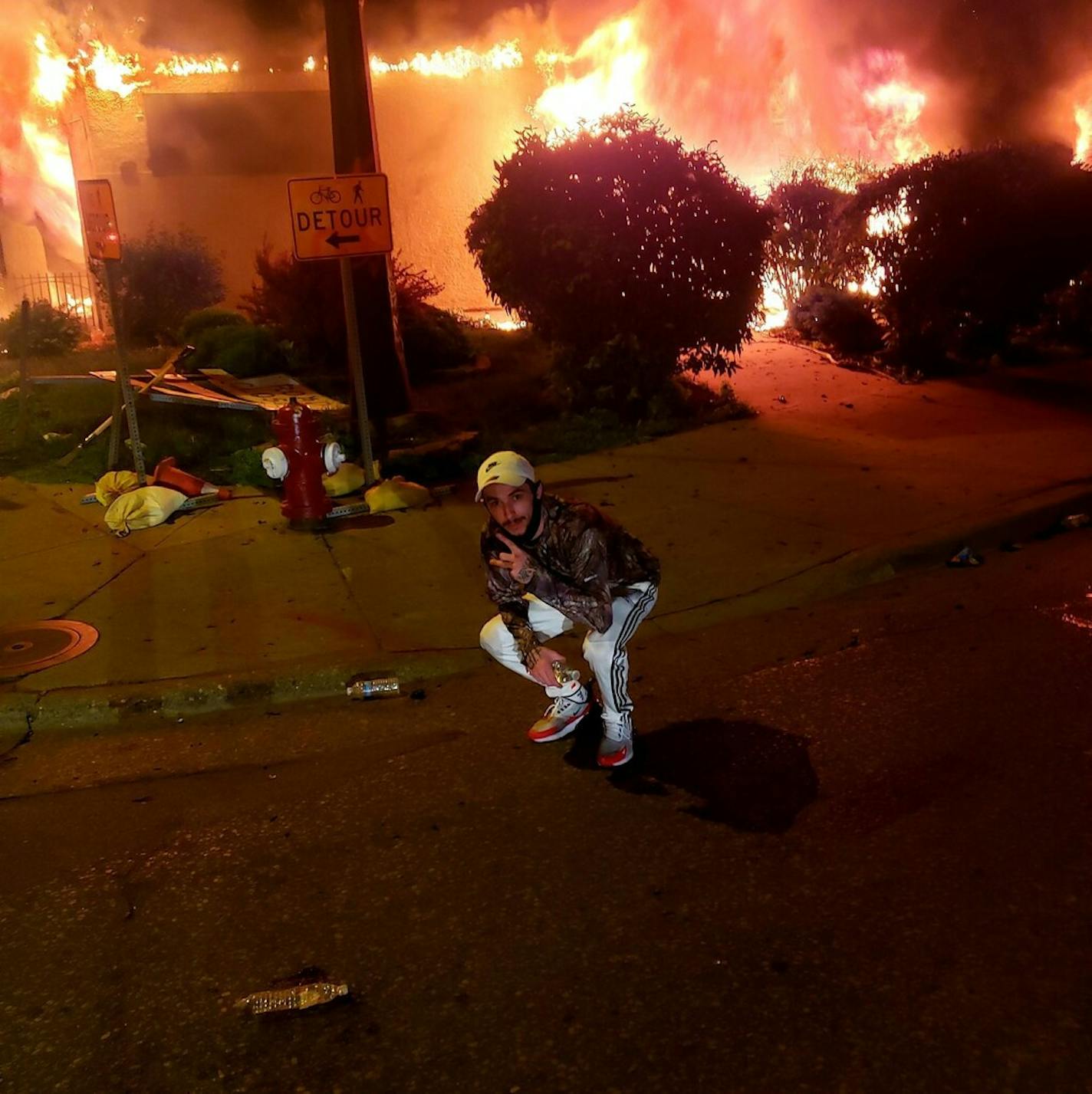 An image of Matthew Lee Rupert in front of a burning building in Minneapolis (Facebook)