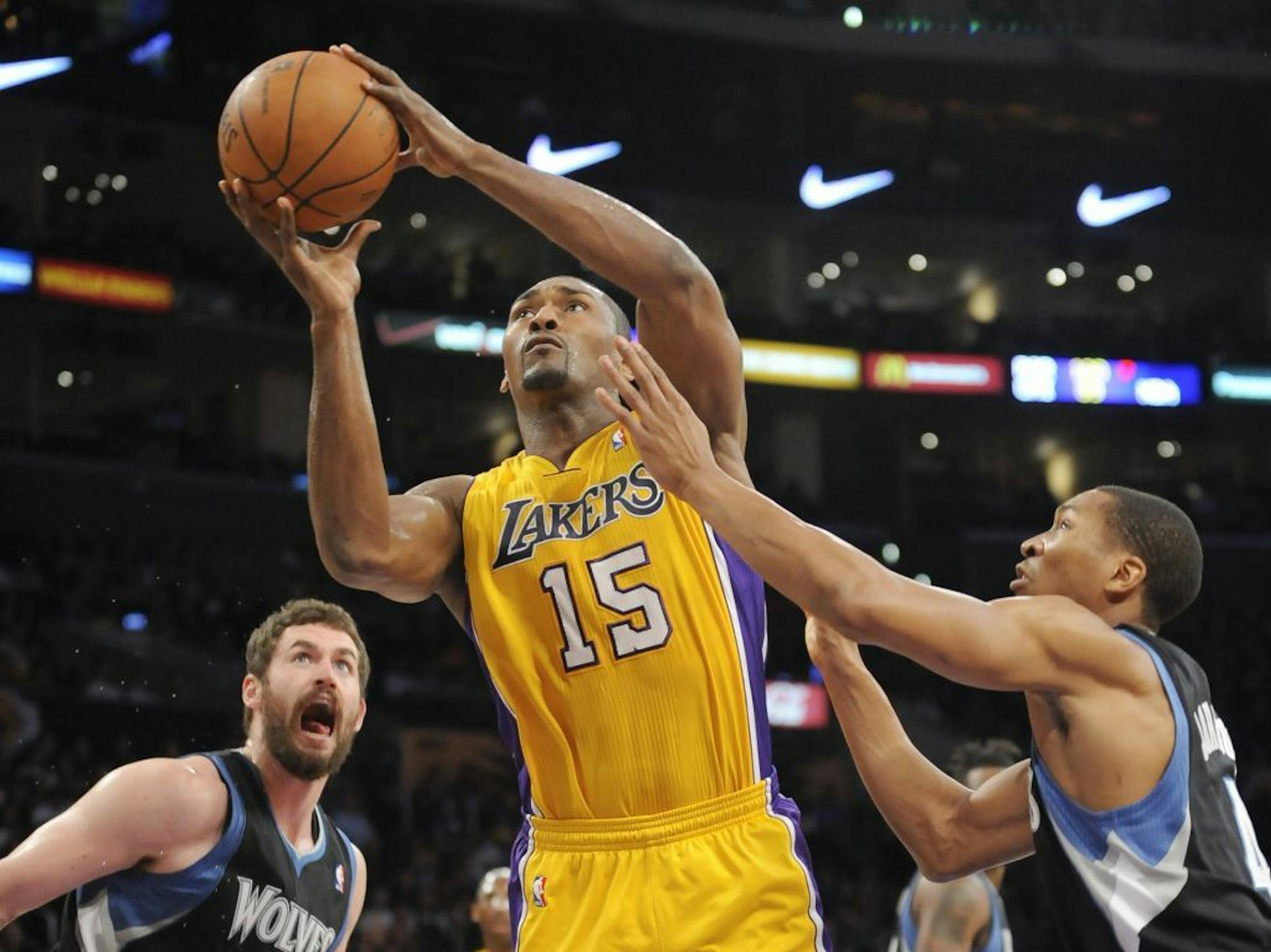 Los Angeles Lakers forward Metta World Peace (15) gets by Minnesota Timberwolves forward Kevin Love, left, and guard Wesley Johnson, right, for a basket in the first half of an NBA basketball game, Friday, March, 16, 2012, in Los Angeles.