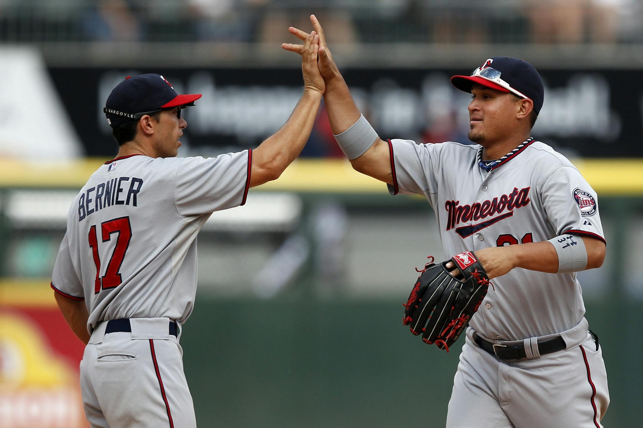Minnesota Twins shortstop Doug Bernier (17) and left fielder Oswaldo Arcia (31) celebrate after they defeated the Chicago White Sox in a 5-2 victory in a baseball game in Chicago, Sunday, Aug. 11, 2013.