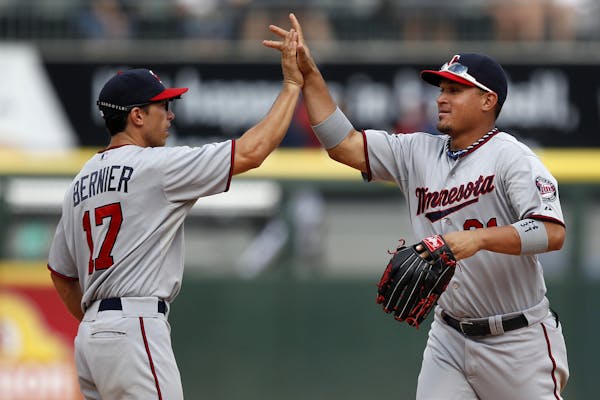 Minnesota Twins shortstop Doug Bernier (17) and left fielder Oswaldo Arcia (31) celebrate after they defeated the Chicago White Sox in a 5-2 victory i