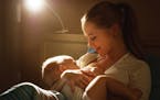 Breastfeeding. mother feeding baby breast in bed dark night(Dreamstime/TNS) ORG XMIT: 1233045