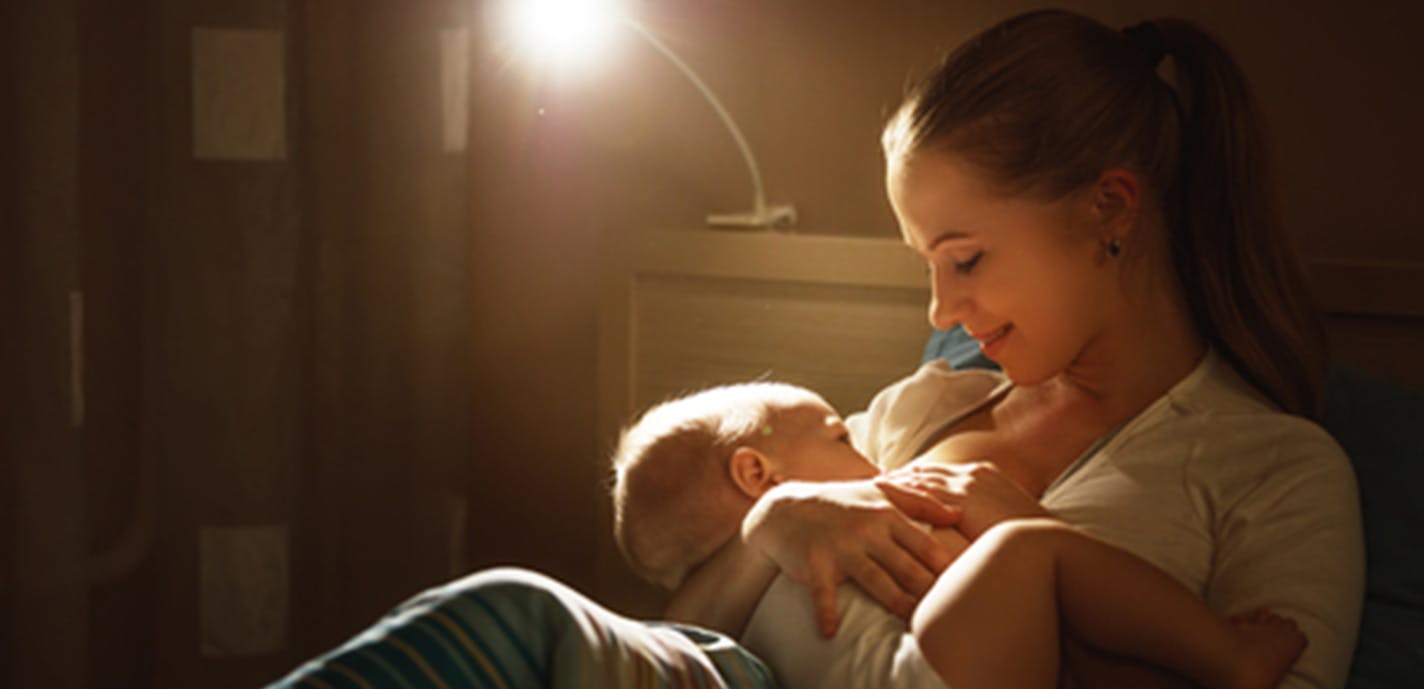 Breastfeeding. mother feeding baby breast in bed dark night(Dreamstime/TNS) ORG XMIT: 1233045