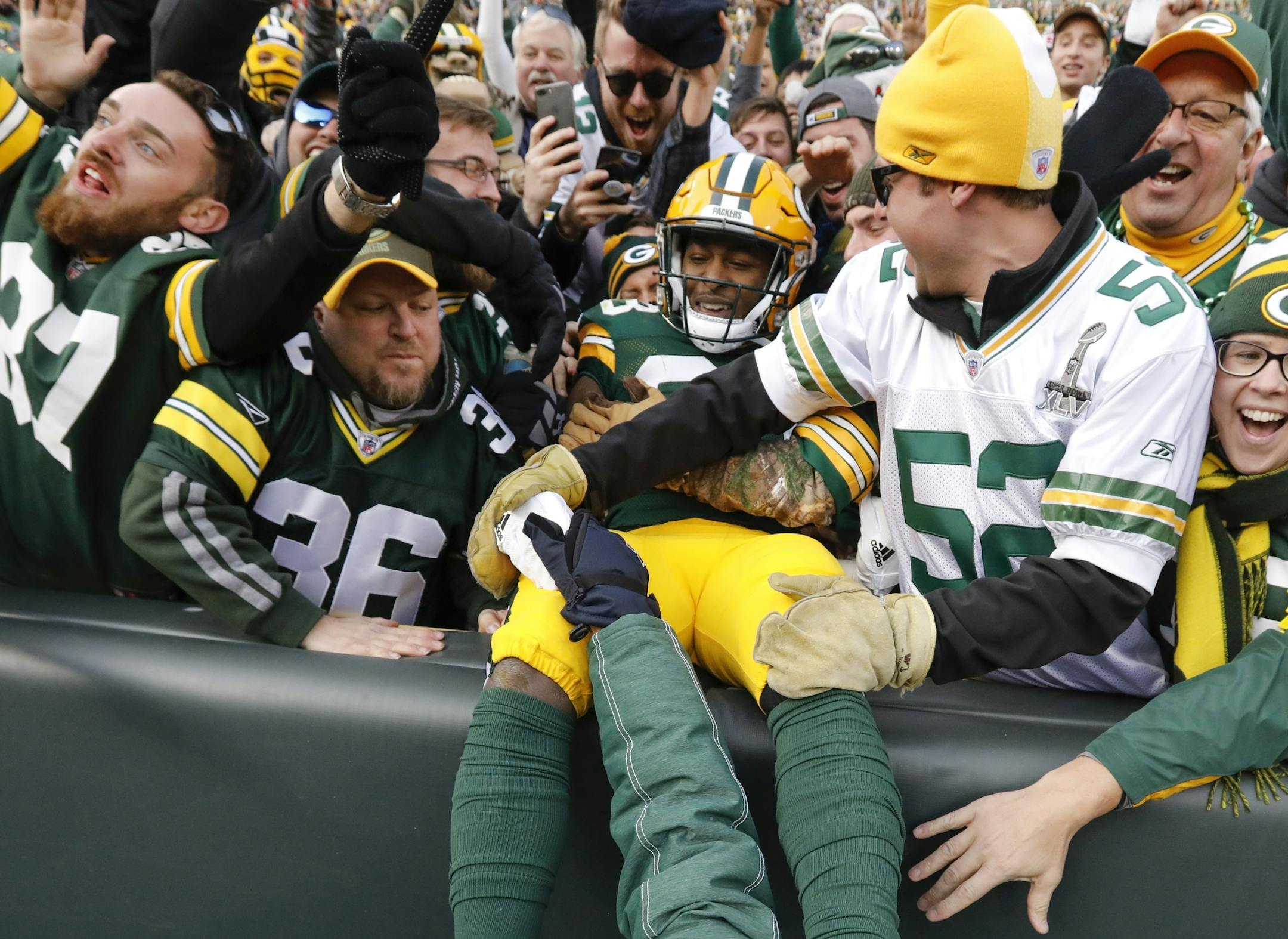 Green Bay Packers' Aaron Jones celebrates his touchdown run with fans during overtime of an NFL football game against the Tampa Bay Buccaneers Sunday, Dec. 3, 2017, in Green Bay, Wis. The Packers won 26-20. (AP Photo/Mike Roemer)