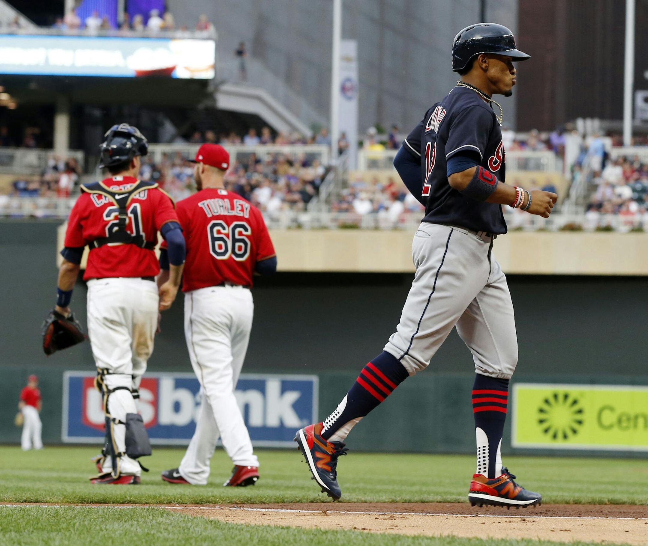Cleveland Indians' Francisco Lindor, right, jogs home on a three-run home run by Edwin Encarnacion as Minnesota Twins catcher Jason Castro, left, talks with pitcher Nik Turley in the third inning of a baseball game Friday, June 16, 2017, in Minneapolis. (AP Photo/Jim Mone)