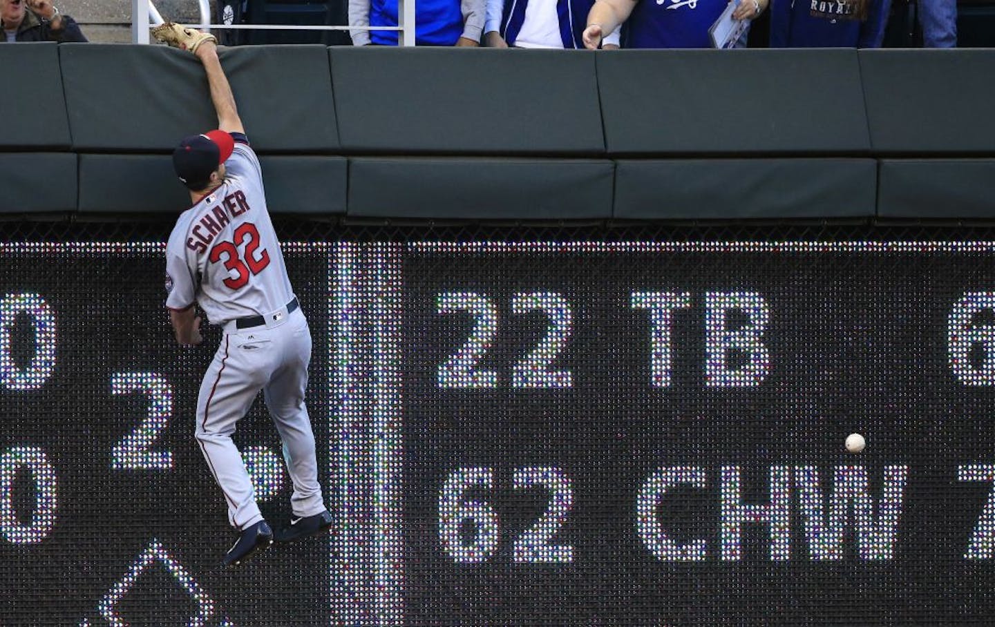 Minnesota Twins left fielder Logan Schafer climbs the wall after a fly ball hit by Kansas City Royals' Paulo Orlando during the second inning of a baseball game at Kauffman Stadium in Kansas City, Mo., Thursday, Sept. 29, 2016. Orlando doubled on the play.