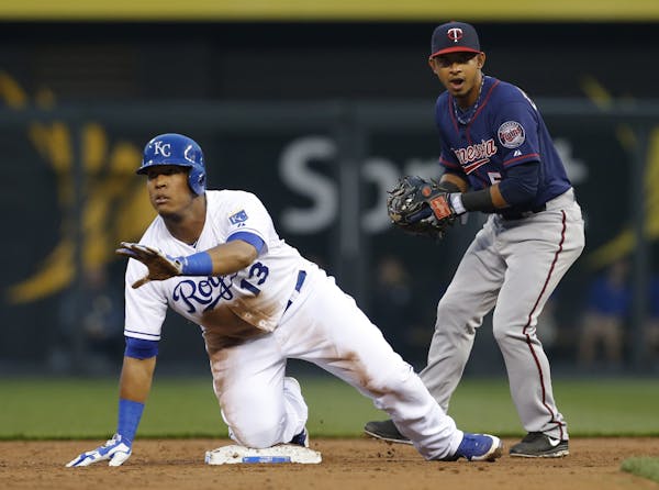 Kansas City Royals' Salvador Perez asks for timeout while Twins shortstop Eduardo Escobar handles the throw from the outfield.