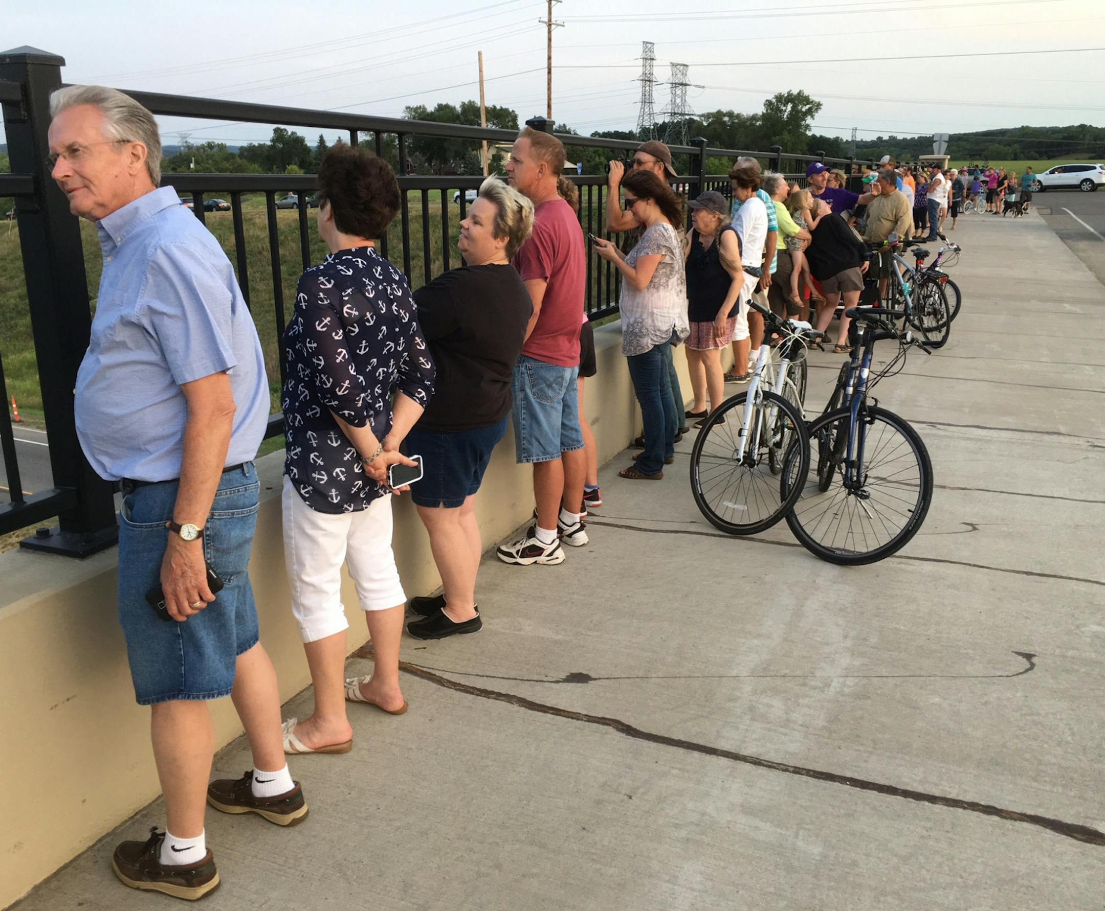 Spectators watch as the first cars to cross the St. Croix River bridge leave Oak Park Heights on Wednesday on their way to the milelong span. 8/2/17