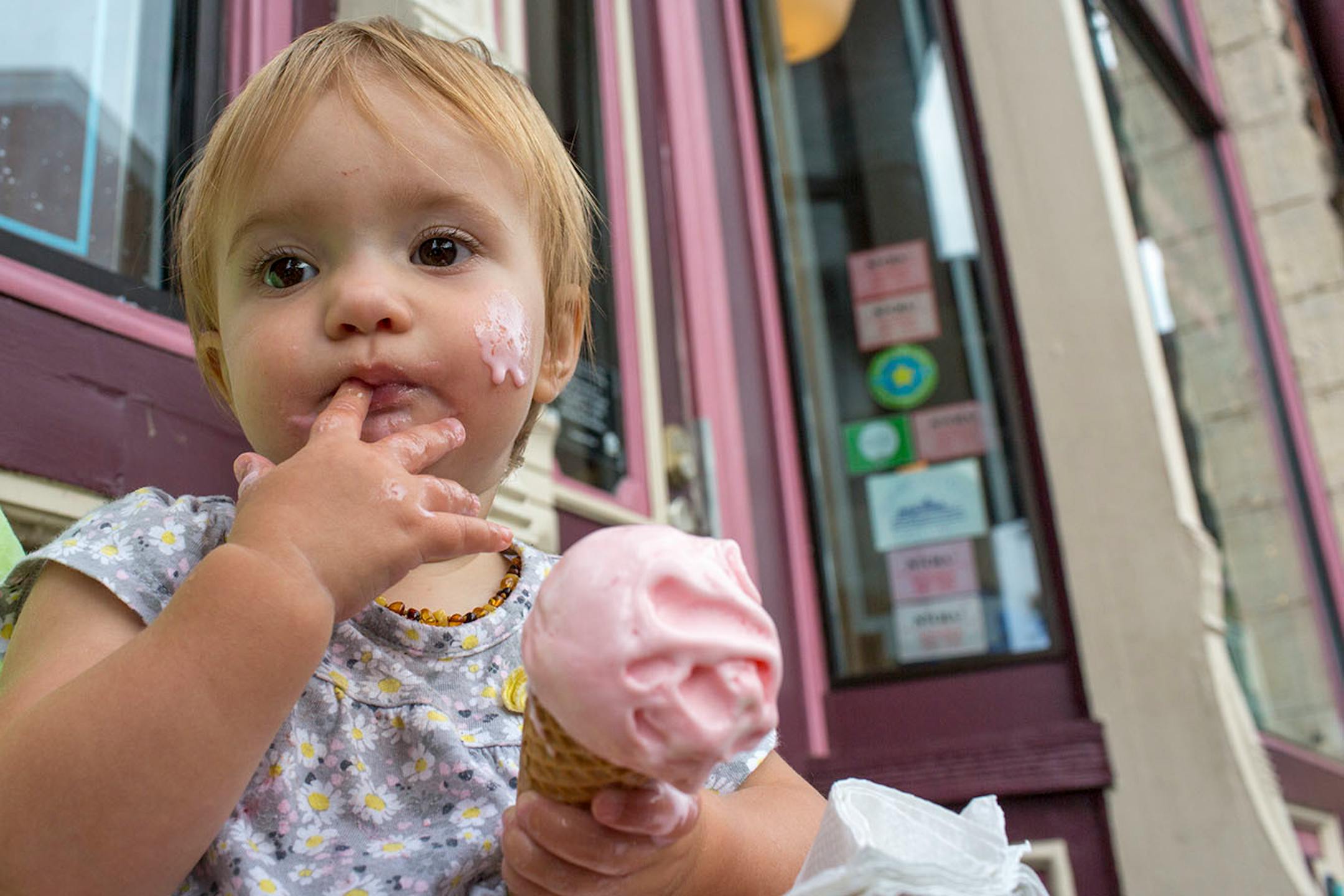 Annaliese Beers, 1, holds the ice cream that has also touched her cheek outside of the Pearl Ice Cream Parlor. ] COURTNEY PEDROZA • courtney.pedroza@startribune.com June 22-24, 2017; Wisconsin restaurants, cafes, bars, bakeries and breweries; Dining along the Mississippi River.