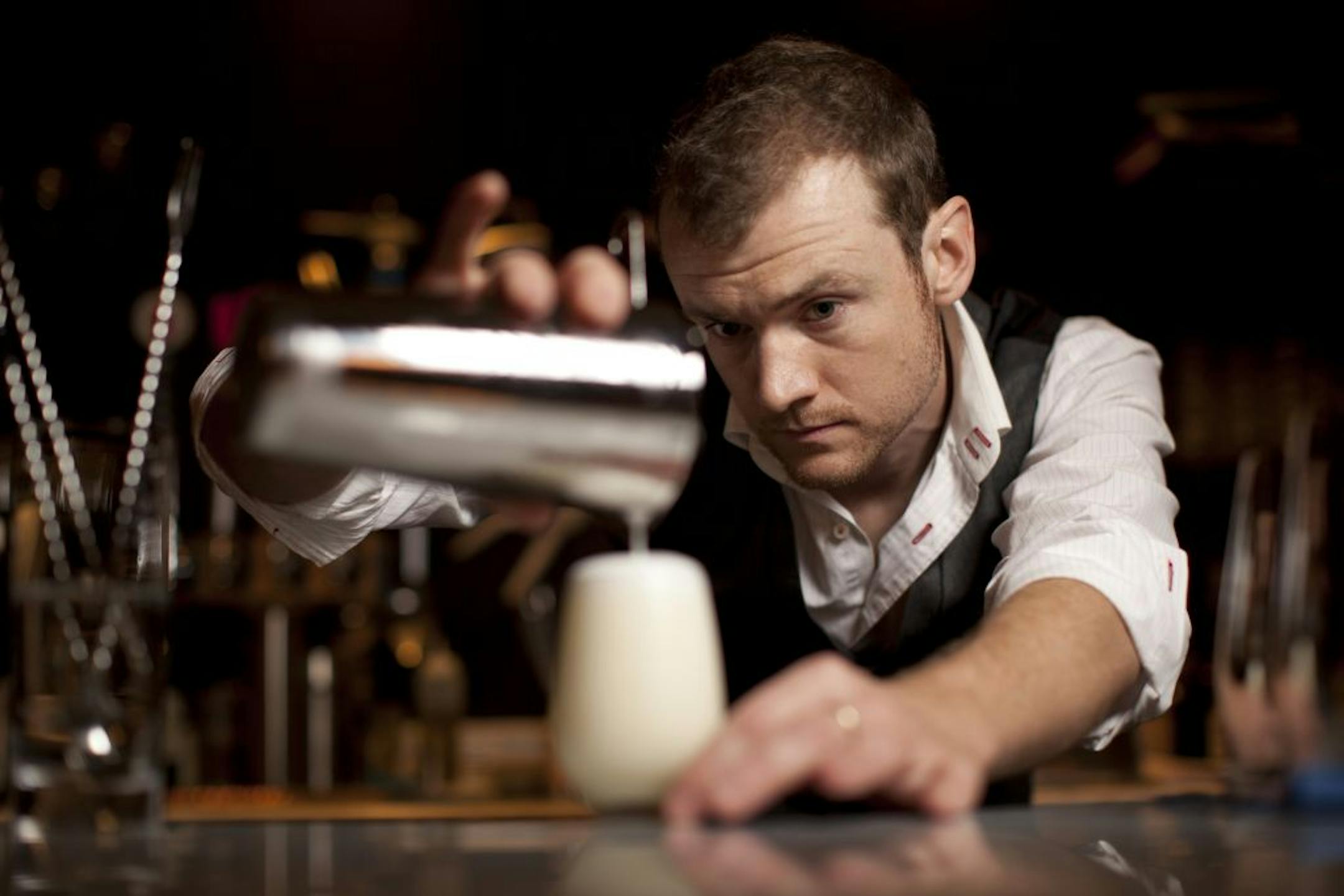 Mixologist Pip Hanson in his natural habitat, pouring a cocktail behind the bar at Marvel Bar.