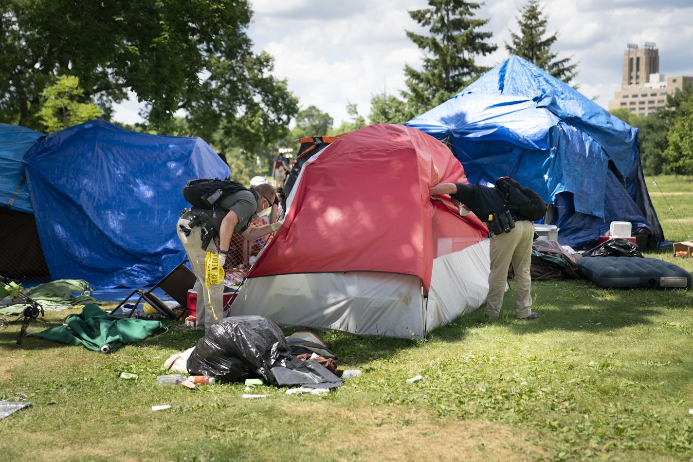 Police looked in a tent to see if there were any occupants before demolishing it and trashing it at the east side homeless encampment at Powderhorn Park in Minneapolis, Minn., on Monday, July 20, 2020. ] RENEE JONES SCHNEIDER renee.jones@startribune.com