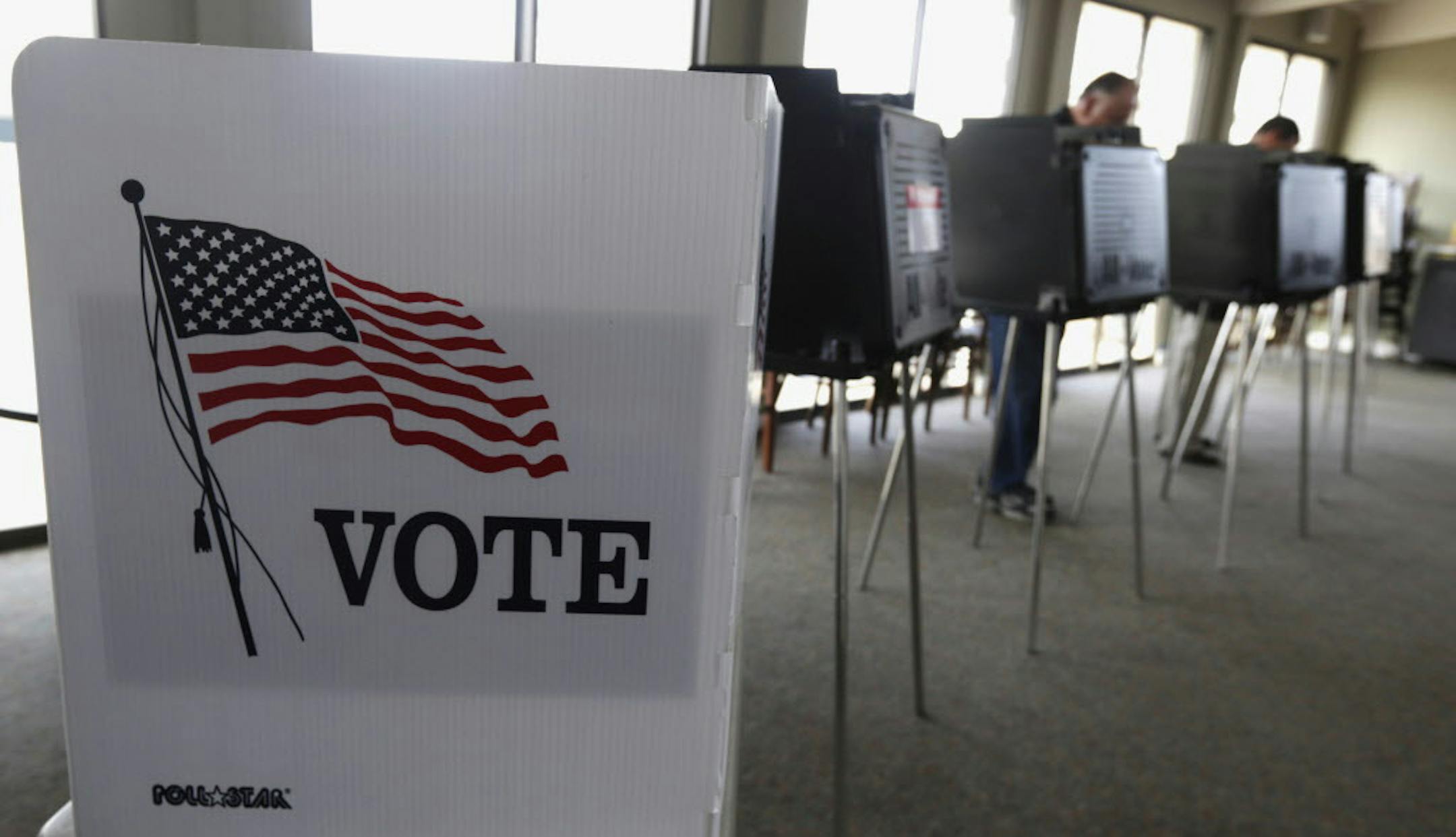 FILE - In this March 18, 2014 file photo, voters cast their ballots in Hinsdale, Ill. The number of Illinois residents who have voted ahead of Election Day has broken state records and is still growing. The State Board of Elections released totals Monday Nov. 7, 2016 showing the number of voters who cast in-person ballots through Sunday was approaching 1.3 million. (AP Photo/M. Spencer Green, File)